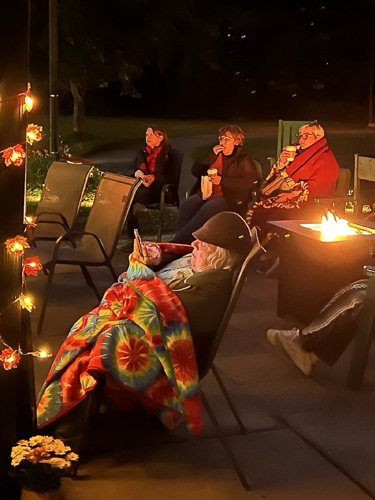 Members enjoy a summer evening in courtyard, after dark